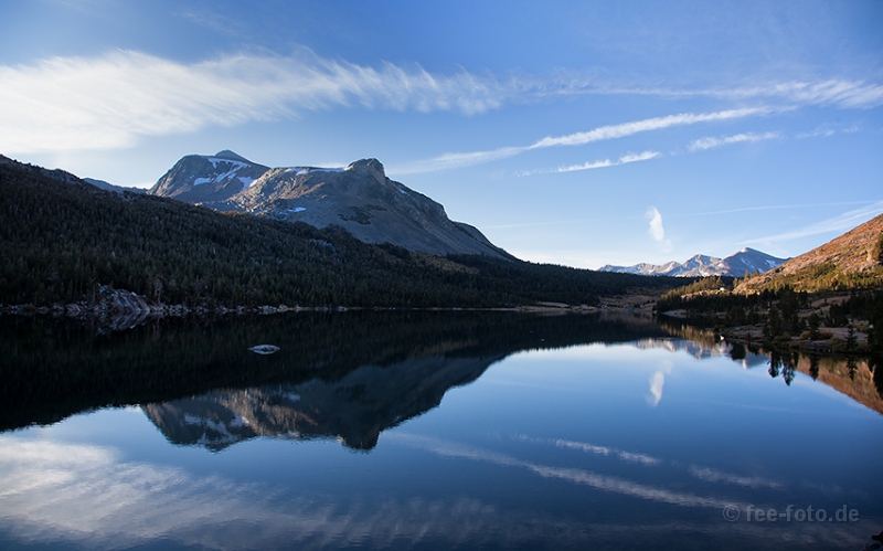 Erste Sonnenstrahlen lassen das Ufer erstrahlen